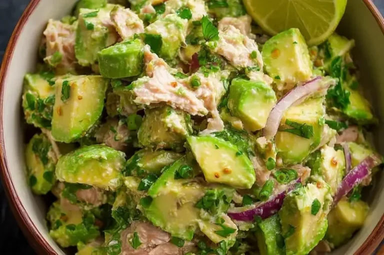 Bowl of fresh Avocado Tuna Salad with greens and ingredients displayed