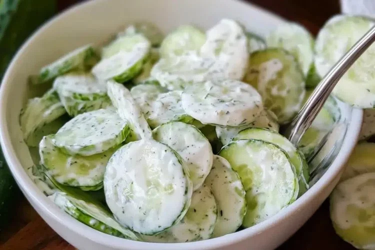 Delicious creamy cucumber salad served in a bowl with fresh herbs