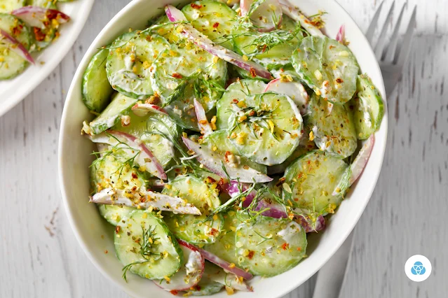 Creamy cucumber salad in a bowl garnished with herbs and spices