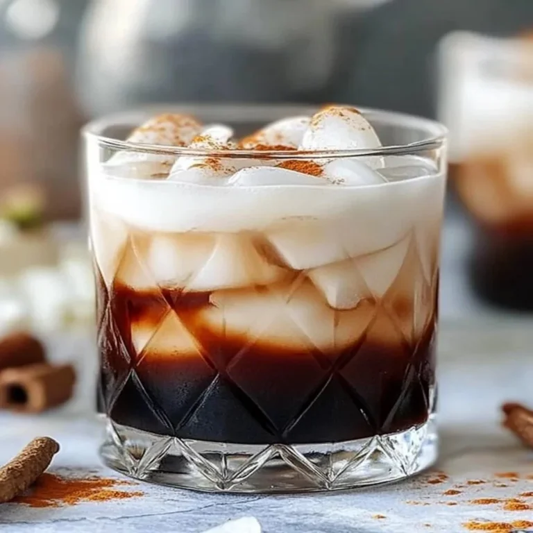 Creamy root beer rum cocktail in a glass with a frothy topping