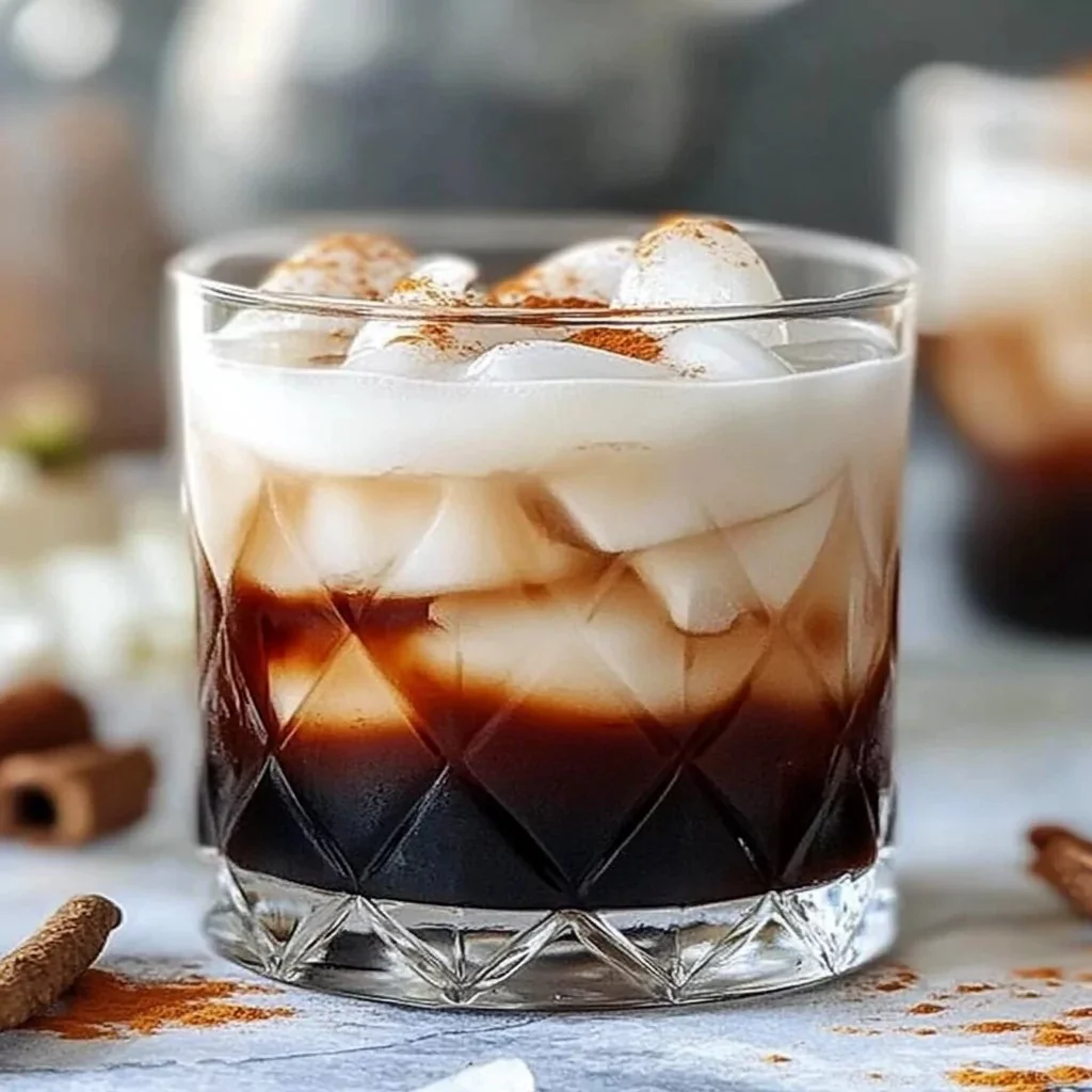 Creamy root beer rum cocktail in a glass with a frothy topping