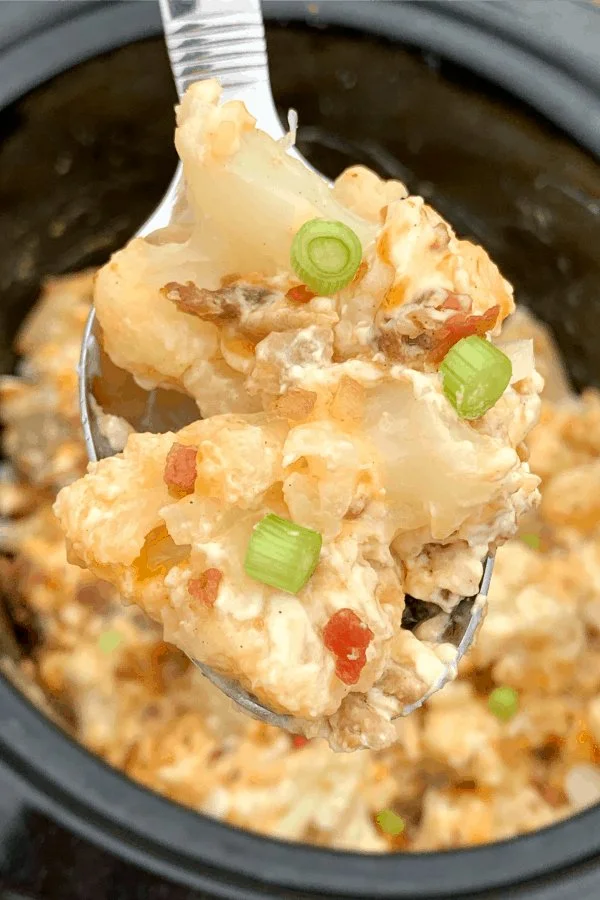 Crock Pot Loaded Cauliflower Casserole garnished with herbs and cheese