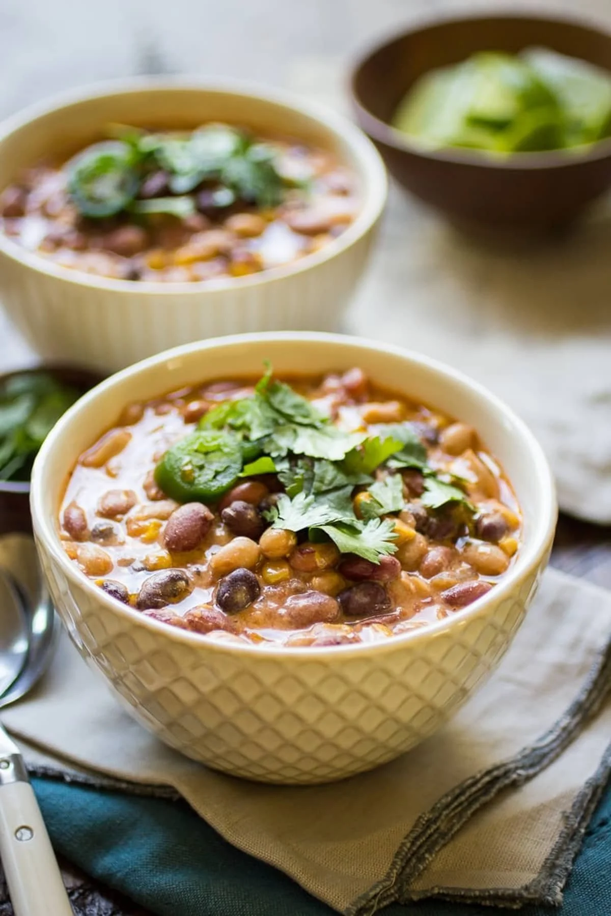 Bowl of hearty vegetarian chili garnished with herbs and spices