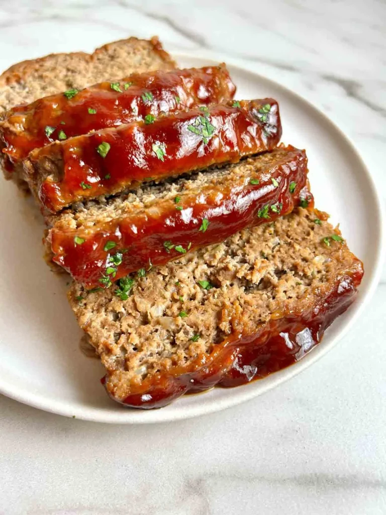 Homemade meatloaf served with mashed potatoes and green beans.