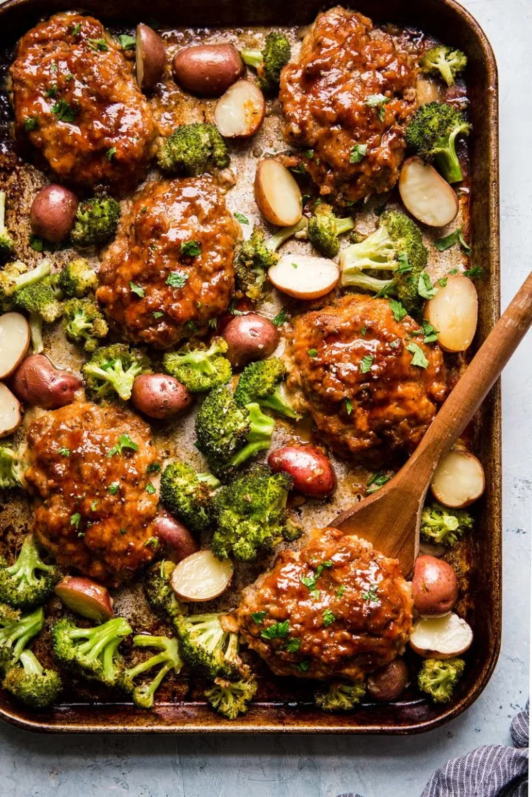 Mini Italian-Style Meatloaf on a sheet pan, garnished with herbs and vegetables.