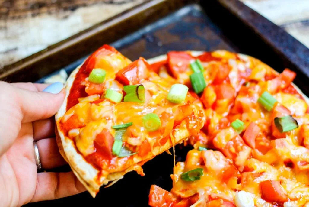 Copycat Taco Bell Mexican pizzas topped with cheese, beans, and tomatoes