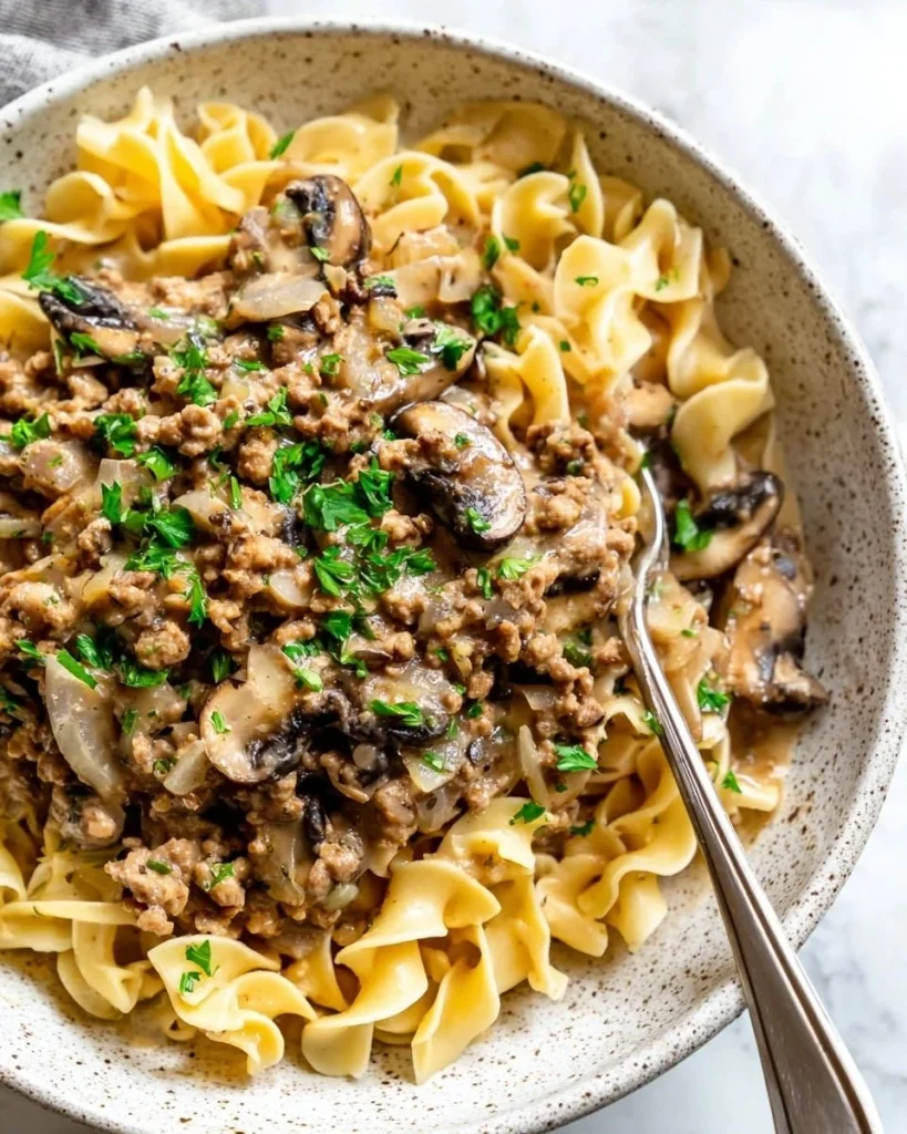 Creamy chicken stroganoff with mushrooms and fresh herbs served in a bowl