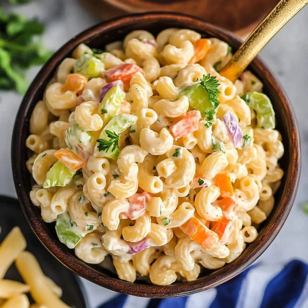 Bowl of easy macaroni salad garnished with herbs and vegetables