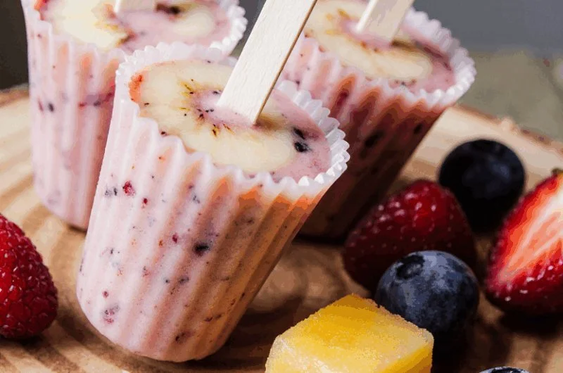 Colorful frozen yogurt fruit pops with various fruits for a refreshing snack