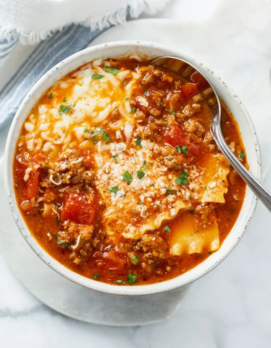 Delicious bowl of lasagna soup garnished with cheese and herbs