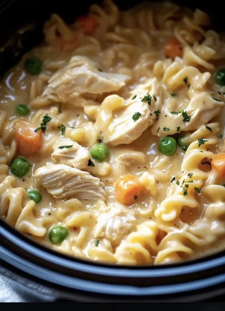 Slow cooker chicken pot pie pasta in a bowl garnished with herbs