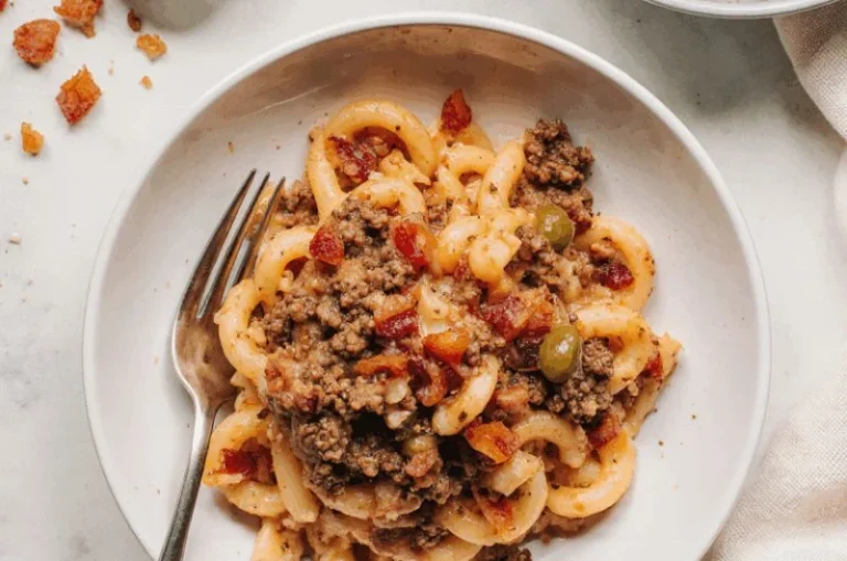 Plate of Spanish noodles with ground beef garnished with parsley.